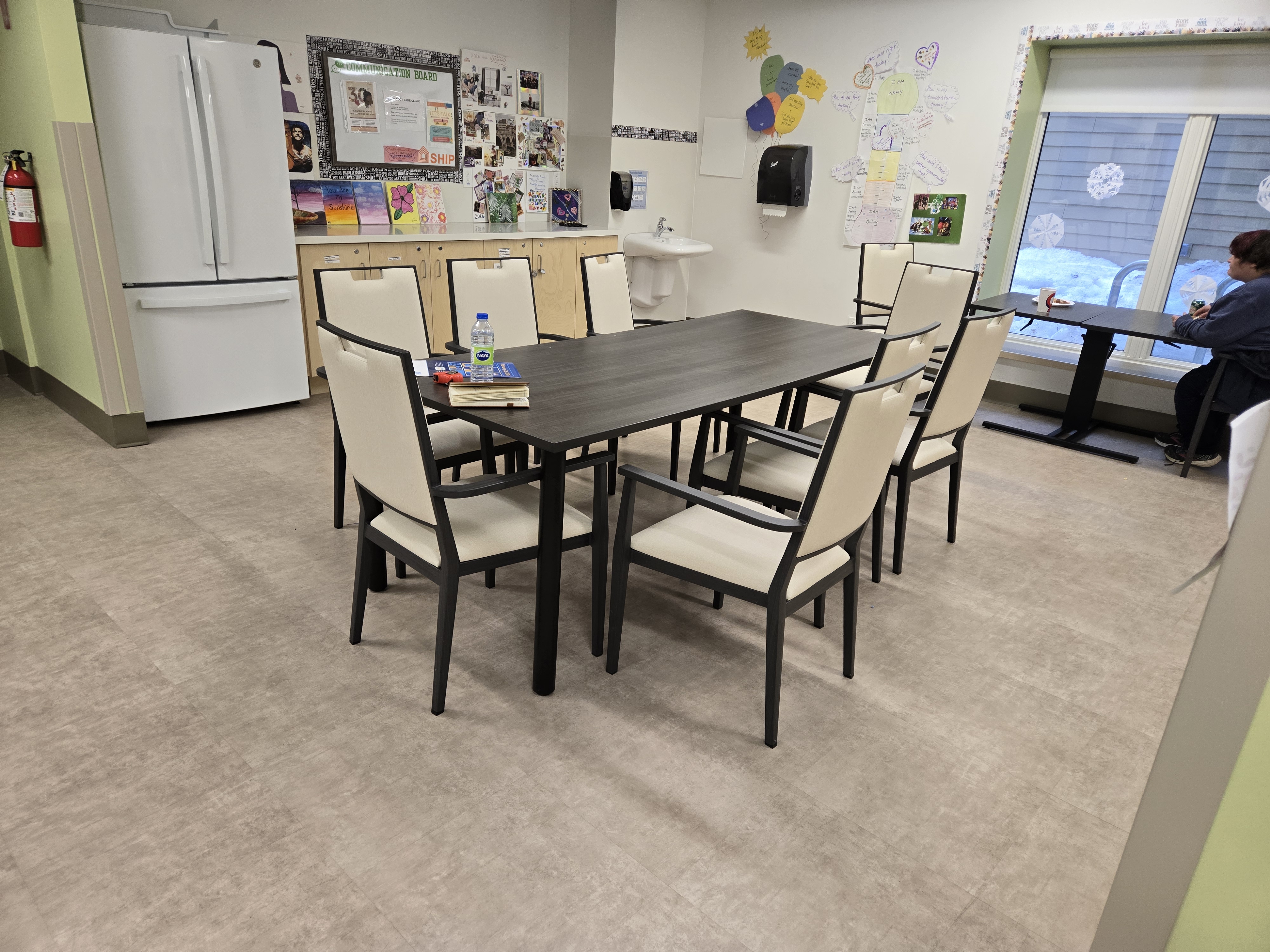 Care-community dining and activity room furnished with IntelliCare dining tables and upholstered dining chairs